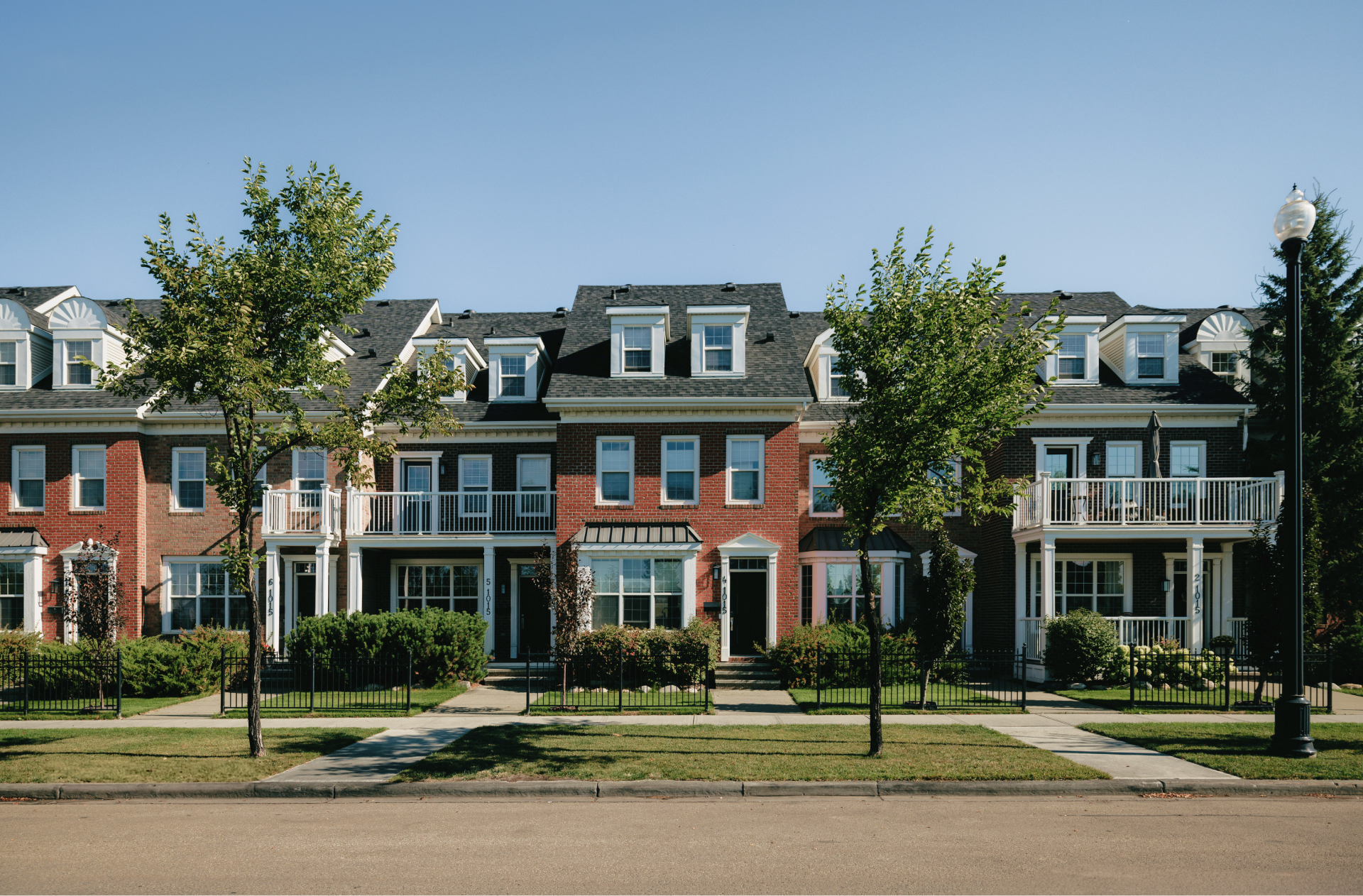 A row of townhomes on a tree lined street in the Village at Griesbach