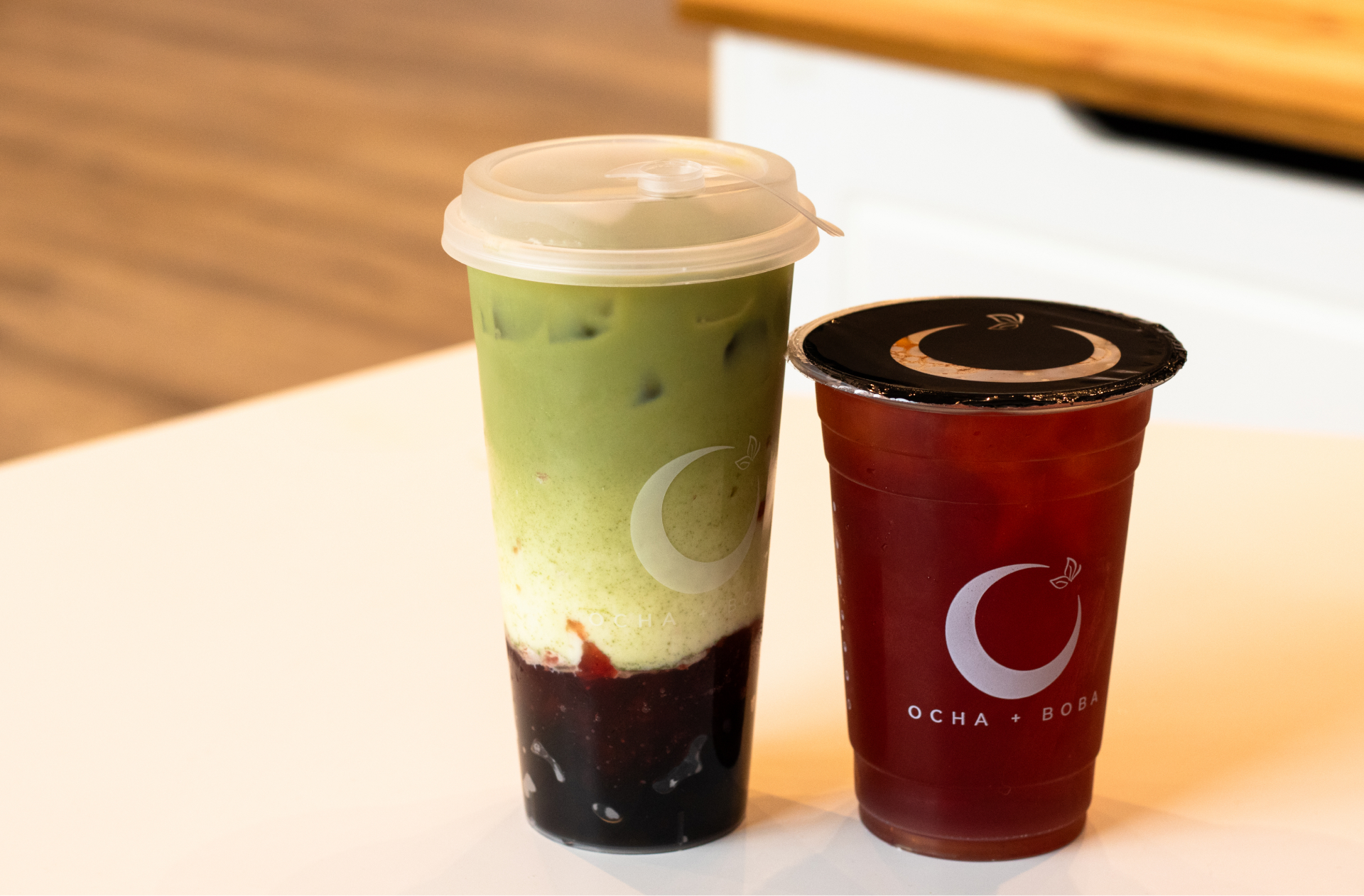 A matcha and berry flavoured drink and a bubble tea from Ocha + Boba